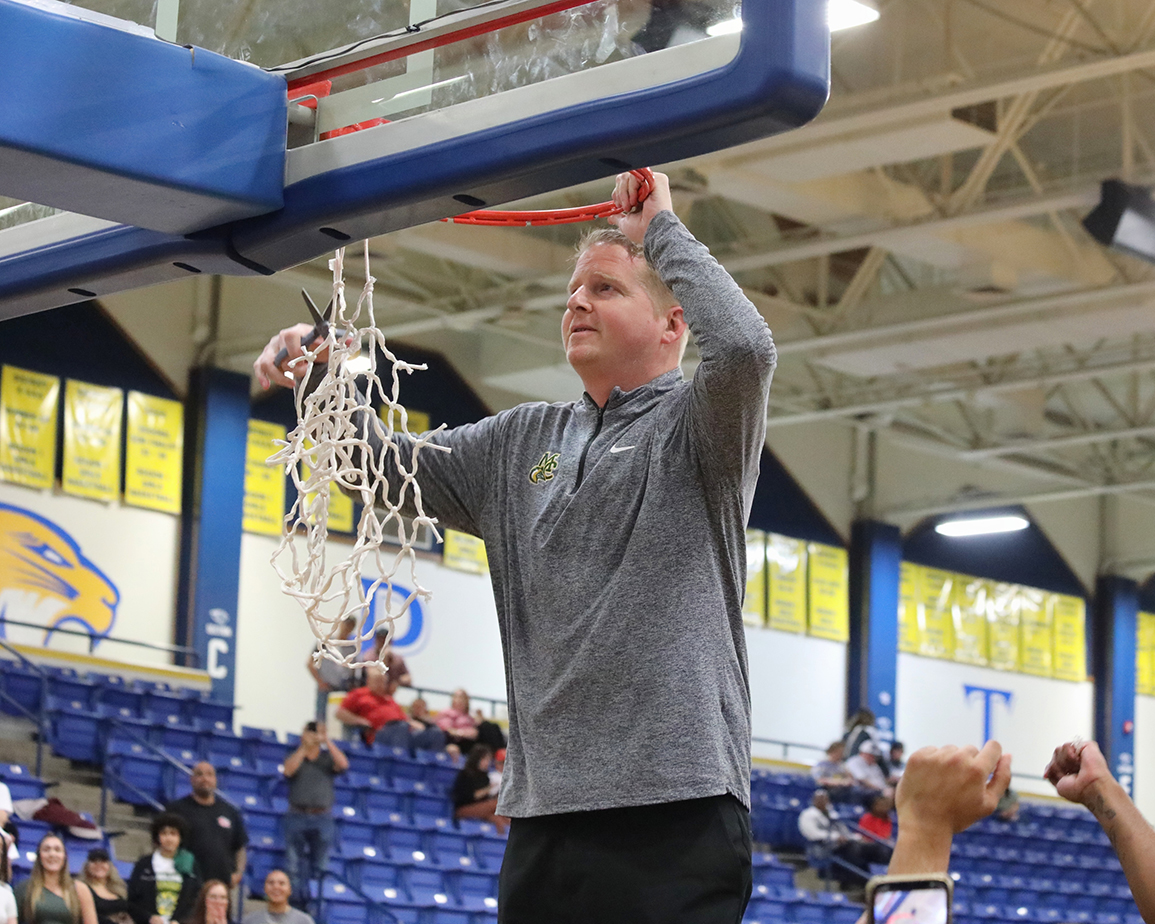 Tra Arnold, MC Chaparral Men's Basketball head coach clips the net following the Chaps' championship victory